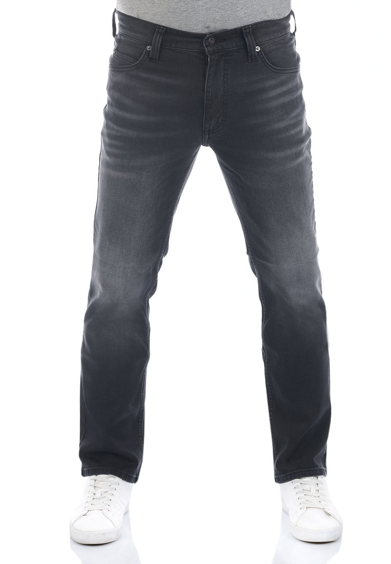 Jeans in denim grigio scuro con una linea dritta, leggera scoloritura, cinque tasche e dettagli in metallo. Indossati con sneakers bianche.