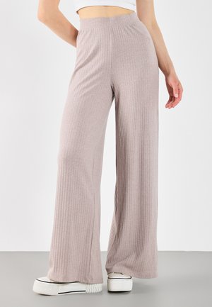 Pantalons larges côtelés rose clair en tissu doux, dotés d'une taille élastique haute et d'une coupe décontractée jusqu'à la cheville.