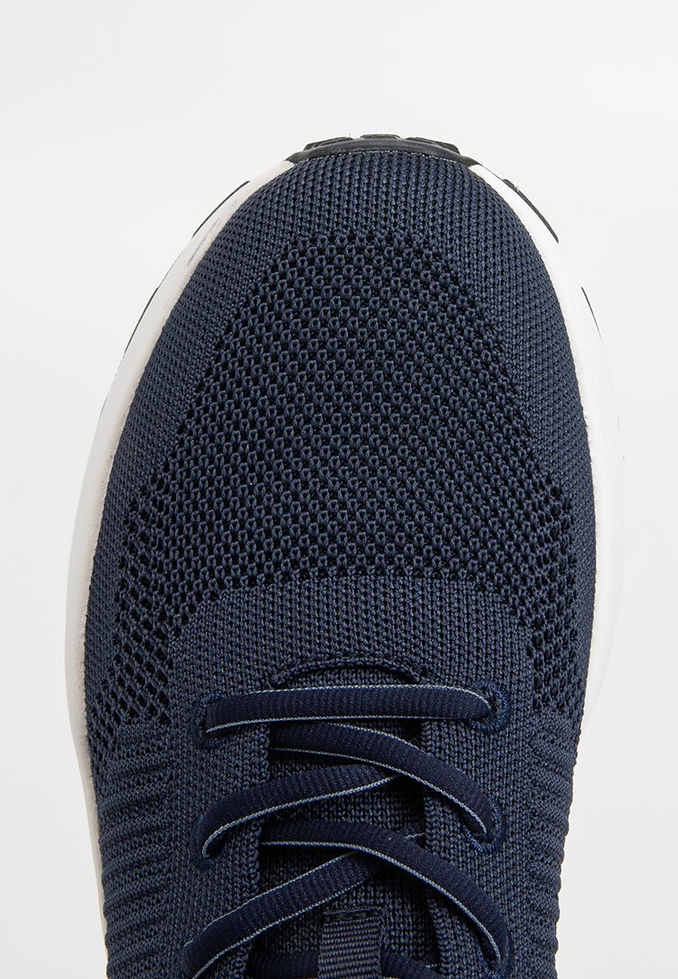 Marineblaue Sportschuhe mit Netz-Obermaterial, runder Spitze und flachen Schnürsenkeln. Sie verfügen über eine strukturierte Oberfläche und eine weiße Zwischensohle zur Dämpfung.