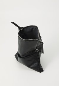 Borsa in pelle nera con texture, chiusa con una zip argentata parzialmente aperta, che mostra un interno semplice e un piccolo dettaglio ad anello sul lato.