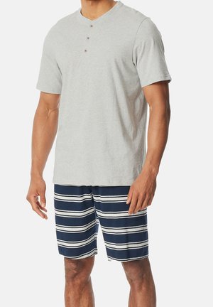 Gray short-sleeve henley shirt with three buttons; paired with navy swim shorts featuring white horizontal stripes and a relaxed fit.