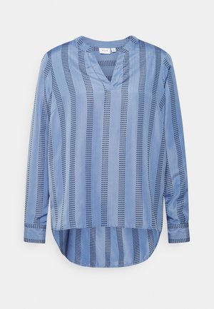 Jasnoniebieska bluzka z długim rękawem, z pionowymi kropkowanymi i pełnymi paskami, dekoltem w kształcie litery V oraz zaokrąglonym dołem dłuższym z tyłu.