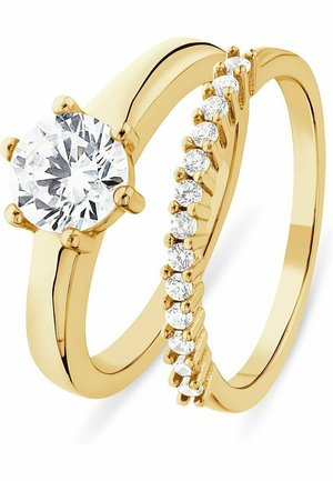 Gold-Verlobungsring-Set mit einem runden Solitärdiamanten und einem Band, das entlang seiner Kante kleinere Akzentdiamanten aufweist.