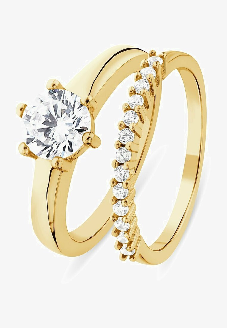 Set di anelli di fidanzamento in oro composto da un diamante solitario rotondo e una fede con piccoli diamanti decorativi lungo il suo bordo.