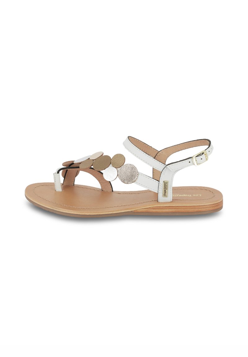 Platte sandalen met witte en beige banden, ronde metalen accenten en een natuurlijke leren inlegzool. Gesp sluiting op de enkelband.