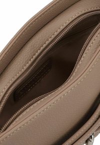Braune Lederhandtasche mit Innenfutter, das zwei Reißverschlussfächer und kontrastierende Nähte aufweist; die Textur ist genarbt mit einem glatten Innenfutter.