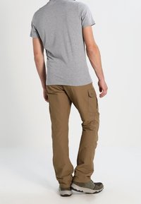 Gray short-sleeve t-shirt paired with khaki cargo pants featuring side pockets. The person is wearing practical, dark footwear.