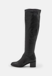 Bota de cuero negro hasta la rodilla con tacón cuadrado, punta ligeramente apuntada y superficie superior lisa, con un diseño holgado.