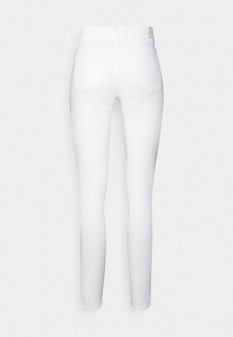 Jeans blancos ajustados con una textura suave, que presentan una cintura de media altura, dos bolsillos traseros y un aspecto limpio y uniforme. Sin desgastes visibles.