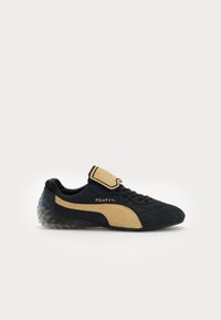 Black and beige suede sneaker featuring a padded tongue, lace-up closure, and clear textured rubber sole. Embroidered "FENTY" logo detail.