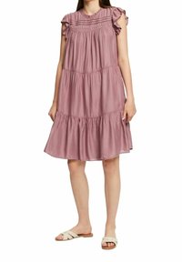 Robe sans manches à volants en tissu mauve doux, avec des détails froncés aux épaules et un corsage texturé à couture plissée.