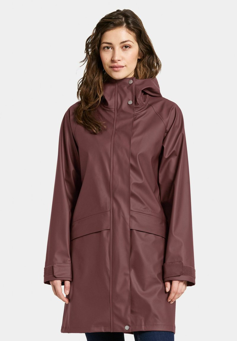 Veste de pluie bordeaux en matériau imperméable, dotée d'un col montant, de fermetures à pression et de deux poches latérales, avec une coupe droite et des manches longues.