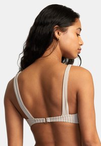 Bralette rayé avec de larges bretelles et une fermeture à crochets au dos, fabriqué dans un tissu doux aux tons neutres. Présente un léger éclat.
