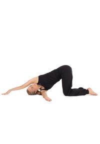 Zwarte sportkleding op een persoon die een yoga-houding aanneemt tegen een witte achtergrond. Armen uitgestrekt, linkerbeen gebogen en rug elegant gebogen.