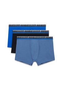 Trīs biksīšu komplekti ar trunku stilu, kas pieejami zilā, melnā un gaiši zilā krāsā, ar elastīgām jostām, uz kurām rakstīts "1981 GUESS EST".