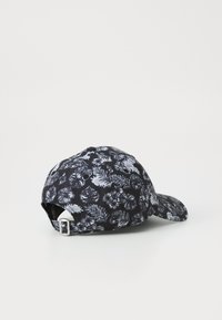 Căciulă neagră cu un model floral în alb și gri, având o vizieră curbată și o curea ajustabilă în spate. Fabricată dintr-un material moale.