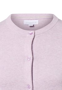 Gilet en lavande avec un col rond, texture côtelée et cinq boutons violet clair. Étiquette de marque "brookshire" visible à l'intérieur.