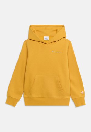 Sweat à capuche jaune Champion avec poche kangourou à l’avant, logo sur la poitrine et la manche, et capuche fixée sur fond blanc uni.