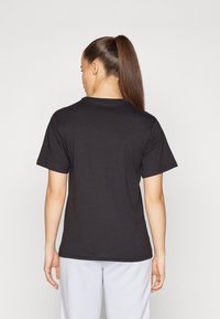 Tricou negru cu mânecă scurtă, fabricat din bumbac, având un guler rotund și o textură netedă. Vederea din spate arată un design simplu, fără embellishments.