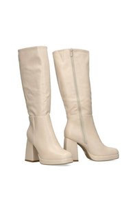 Botas beige hasta la rodilla con un acabado suave, tacón bloque grueso, puntera redondeada y detalle de cremallera en el lateral. Diseño sencillo sin patrones.