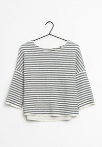 Pasiasty sweter w kolorze granatowym i białym, z szerokim dekoltem, rękawami do łokcia i lekko skróconym hemem. Miękka teksturowana tkanina.