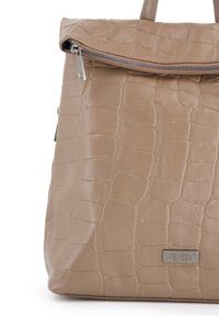 Beige håndtaske med krokodillepræg, med en top lynlås og metal logo plade. Glat overflade med robuste håndtag.