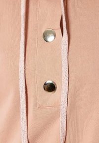 Tela rosa con una textura sutil que presenta dos broches metálicos plateados y un cordón gris claro a lo largo de la apertura. Detalles de diseño simples destacados.
