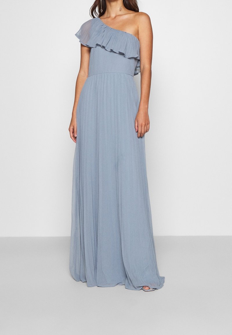 Robe de soirée bleu clair à une épaule avec des détails froncés, jupe plissée et tissu fluide. Le design présente un drapé élégant et une texture douce.