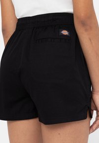 Čierne bavlnené šortky s elastickým pásom, so zadnou vreckom a bočnými rozparky pre pohodlný pohyb. Logo Dickies na páse.