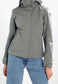 Veste grise à capuche en tissu lisse et léger avec une coupe ajustée, dotée d'une fermeture éclair et de poignets réglables.