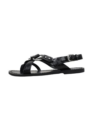 Sandale plate noire avec des brides croisées, une boucle en métal, et un détail anneau rond, dotée d'une bride de cheville ajustable avec une boucle argentée.