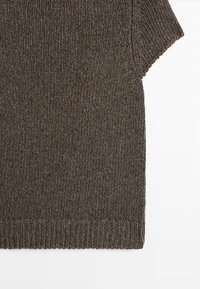 Pull à manches courtes en maille marron avec ourlet côtelé et motif texturé, présenté sur fond blanc.