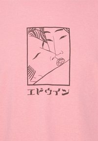 Deux visages stylisés très proches l'un de l'autre, avec la bouche de l'un légèrement ouverte, encadrés par une bordure rectangulaire et un texte japonais en dessous sur un fond rose.