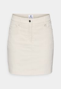 Knee-pikkuses, heleda beeži puuvilla seelik, millel on lukuga lend, ülemine nööpklapp, kaks esist taskut ja minimalistlik disain.
