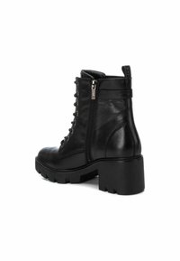 Botas de cuero negro hasta el tobillo con un robusto tacón cuadrado, cremallera lateral y cordones decorativos. Textura suave con punta redondeada.