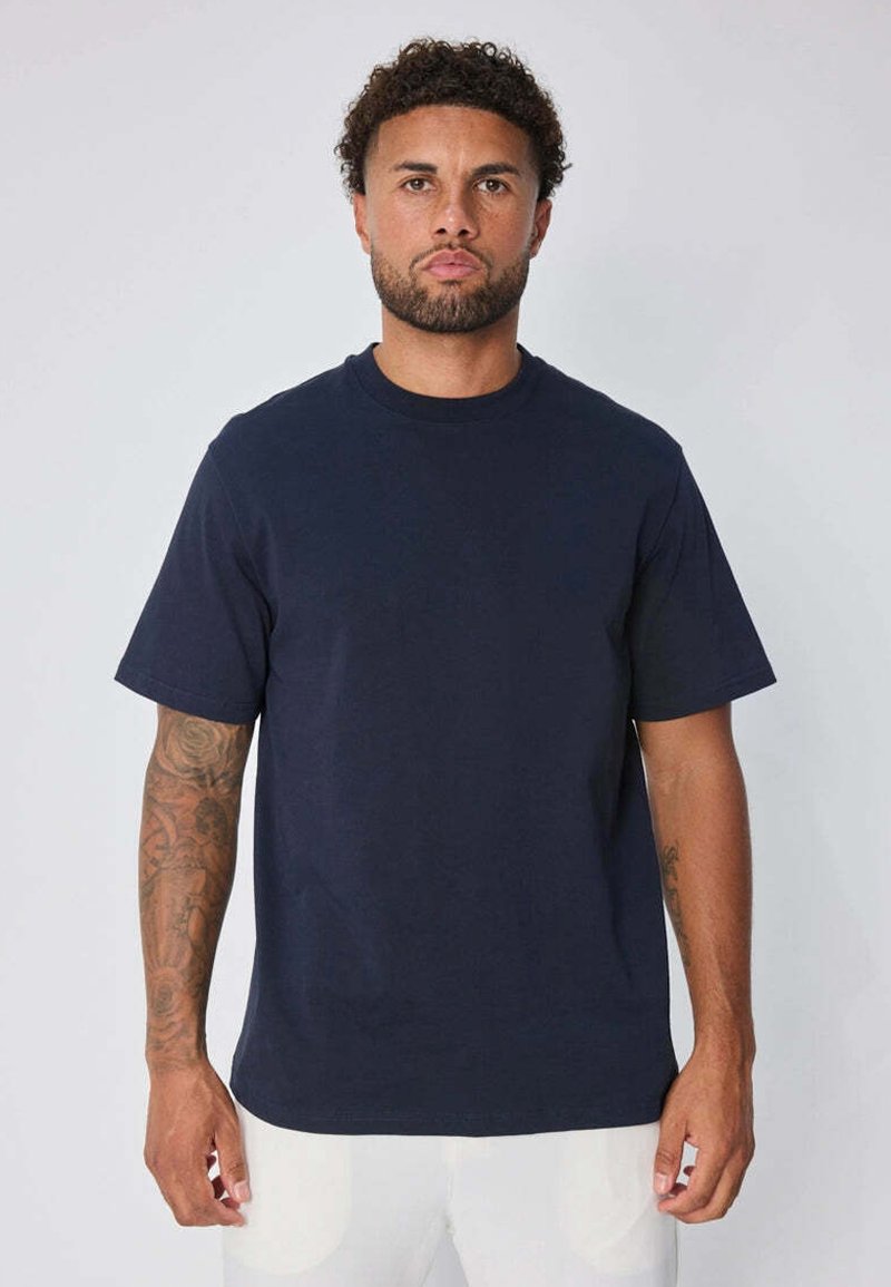 T-shirt en coton bleu marine avec un col rond et des manches courtes, présentant une coupe décontractée et une texture lisse, porté par un mannequin.