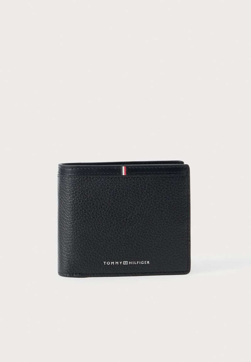 Black leather wallet with a textured finish. Features a small red, white, and blue accent stripe and the "TOMMY HILFIGER" logo. Folded design.