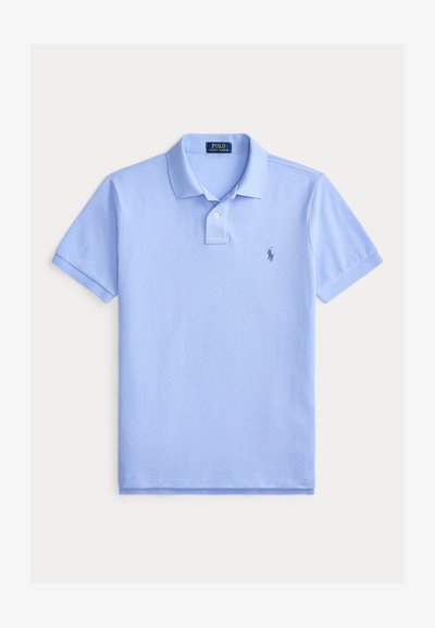 Ανοιχτό μπλε κοντομάνικο πόλο με γιακά, δύο κουμπιά στο μπροστινό μέρος και μικρό σκούρο μπλε κεντημένο λογότυπο στο αριστερό μέρος του στήθους.