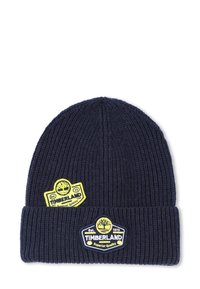 Marineblauwe ribgebreide beanie met twee gele en zwarte Timberland-logo patches op de manchet en zijkant.