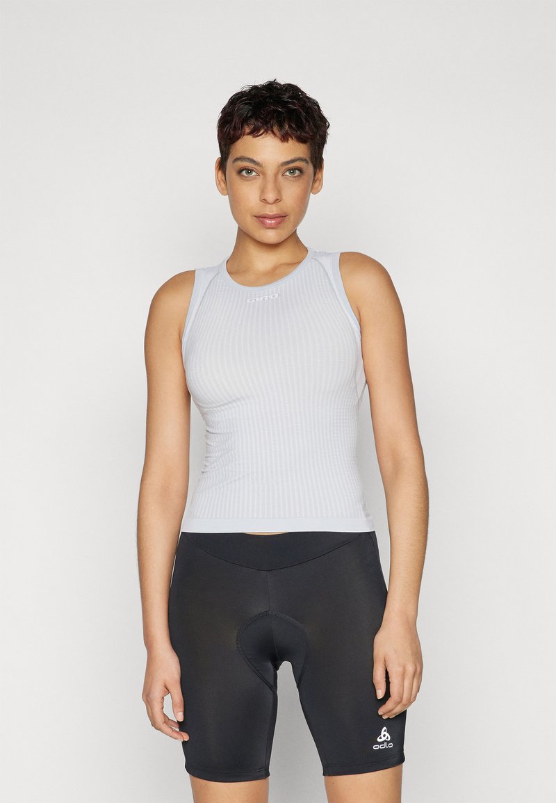 Graues, geripptes Tanktop mit ärmellosem Design, kombiniert mit schwarzen Radsportshorts mit gepolsterter Sitzfläche und einem Logoakzent auf der linken Unterseite.