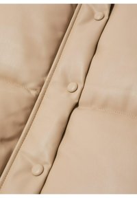 Beige padded jacket featuring smooth faux leather material, rounded buttons, and a quilted design with visible stitching.