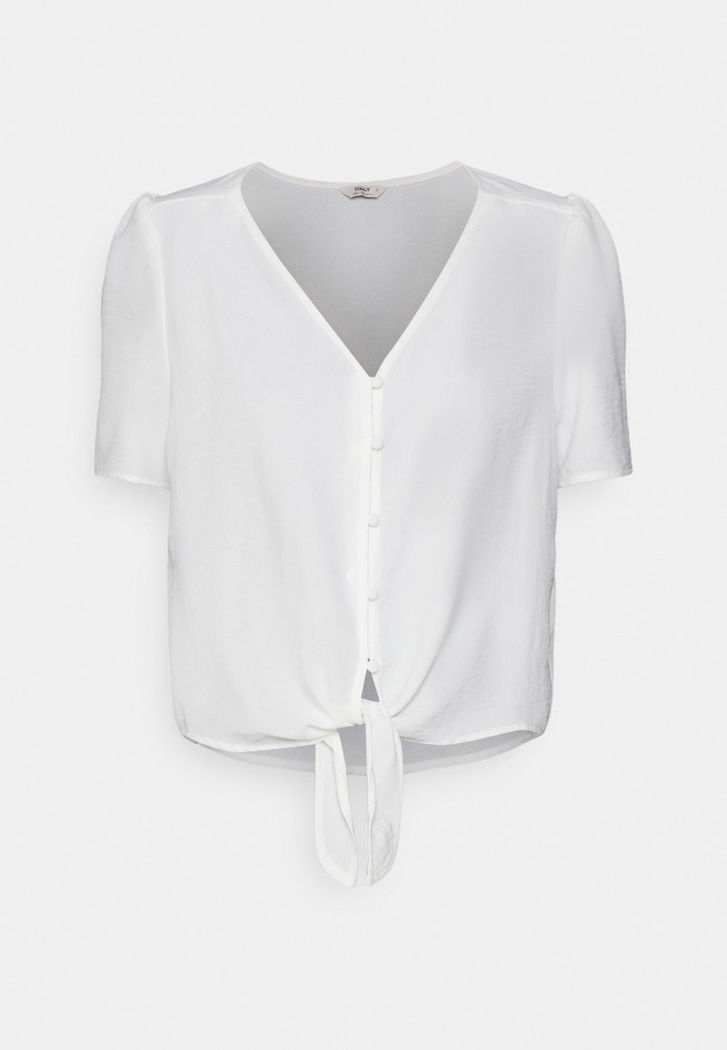 Blouse blanche à manches courtes avec col en V, fermeture boutonnée devant, et détail nœud noué à l'ourlet.