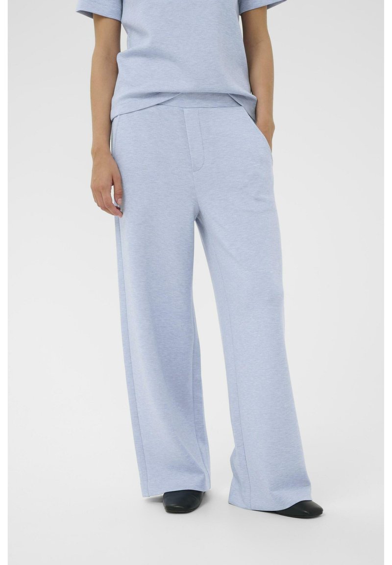Hellblaue Hosen mit weitem Bein aus weichem Stoff, mit Seitentaschen und lockerem Sitz, kombiniert mit einem passenden kurzärmligen Oberteil.