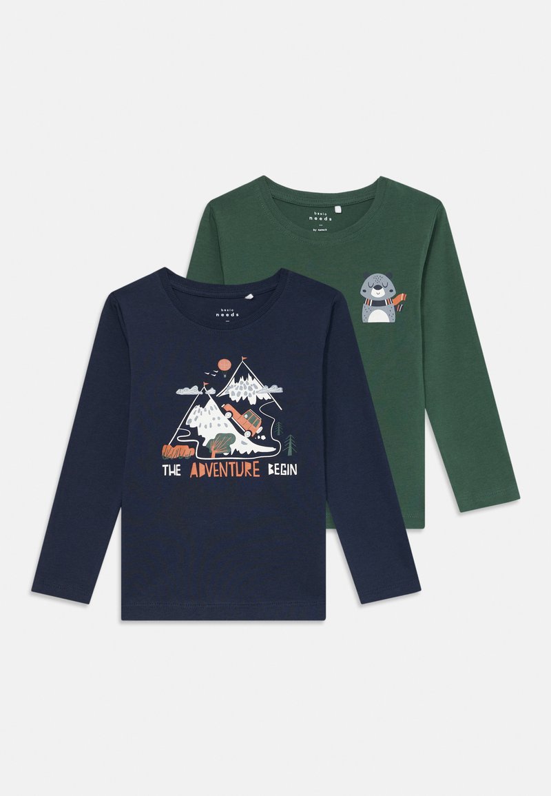 Zwei Langarmhemden: eines in Marineblau mit einem Berg-Graphic und dem Text "DAS ABENTEUER BEGINNT"; das andere in Grün mit einem Cartoon-Tierakzent. Baumwollmaterial.