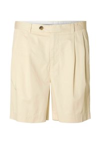 Shorts plissettati beige realizzati in tessuto morbido. Presentano una chiusura con bottone e tasche laterali, con un taglio dritto e lunghezza fino a metà coscia.