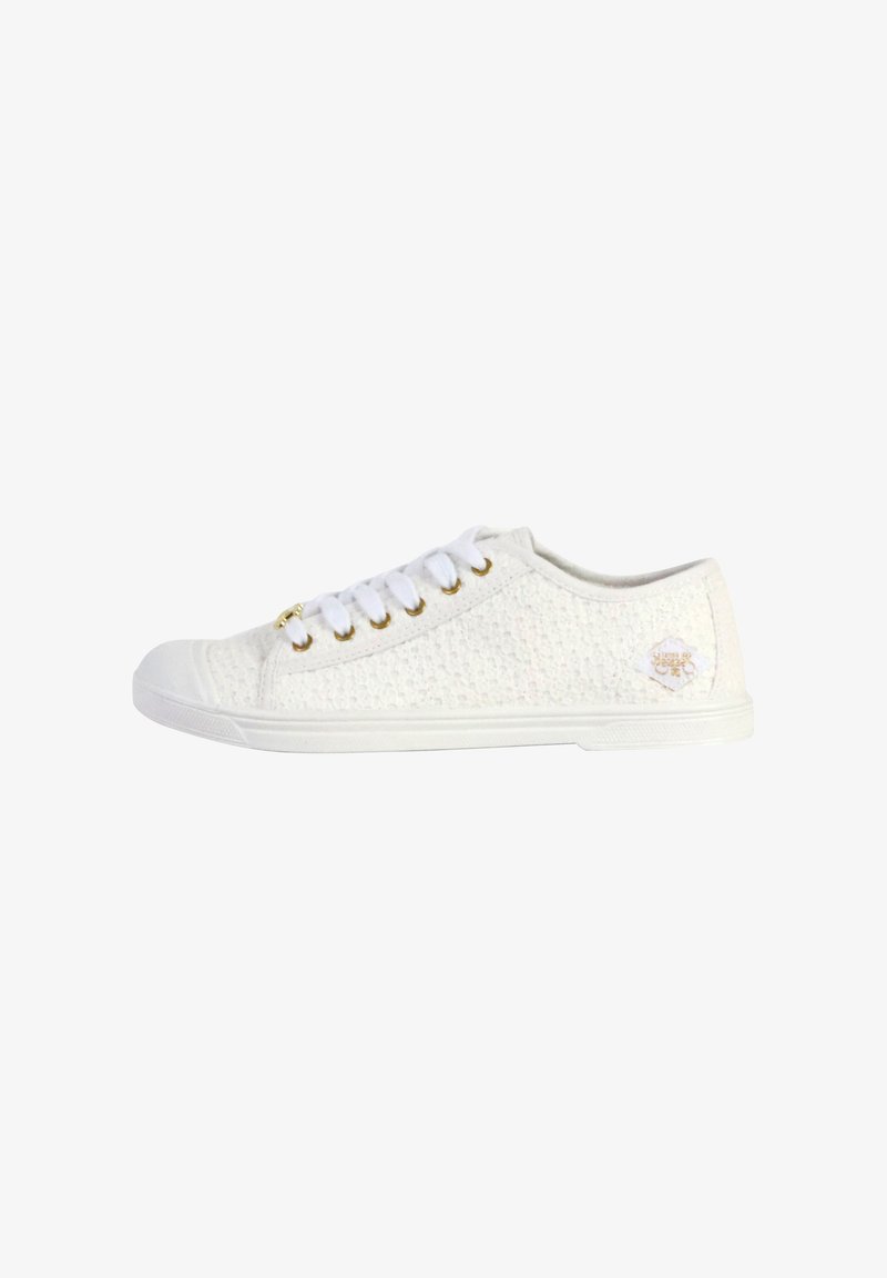 Witte sneaker met een bovenwerk van textuurstof, ronde neus en platte witte zool. Heeft witte veters en goudkleurige oogjes. Klassiek ontwerp.