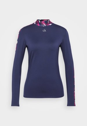 Camisa de manga larga color navy con un cuello alto, con un patrón floral multicolor en los hombros y el logo "ck" en la parte frontal.