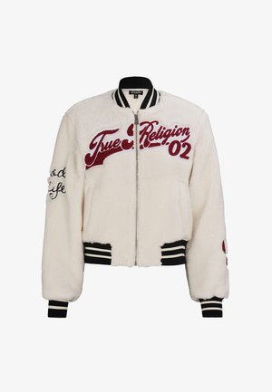 White faux fur bomber jacket with red embroidered "True Religion" text and black accents. Features striped ribbed cuffs and waistband.