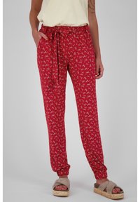 Rode gemusterde broek met een ontspannen pasvorm, elastische tailleband en strikdetail. Heeft taps toelopende enkels en zijzakken. Zachte stof.