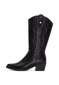 Botas de vaquero de cuero negro con costuras decorativas, punta afilada, tacón de bloque de altura media y tachuelas metálicas a lo largo del borde superior.